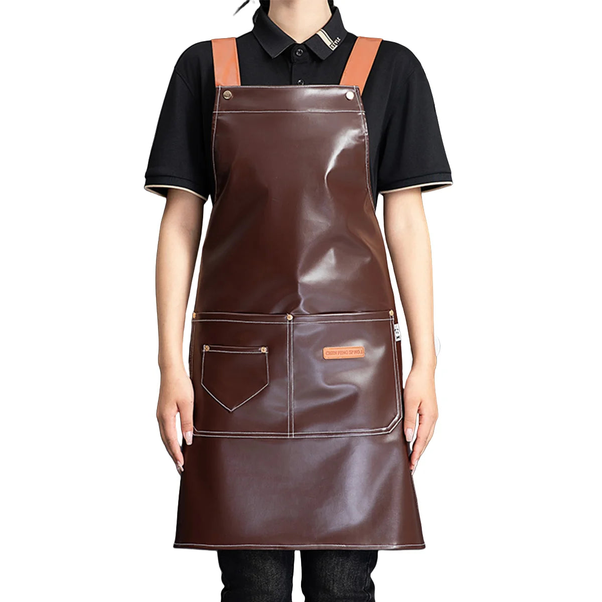 A brown leather apron with multiple pockets and leather straps worn over a black shirt.