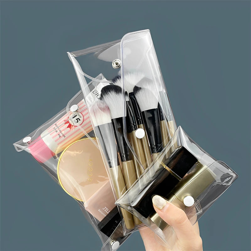 A hand holds a clear cosmetic bag containing makeup brushes and other items for waterproof storage.