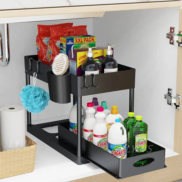 A black two-tier sliding under sink organizer rack with hooks holding various cleaning supplies and toiletries.