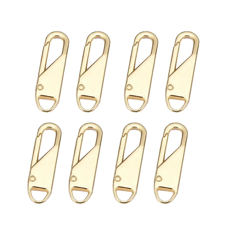 A set of eight gold-colored metal zipper sliders or toggles.