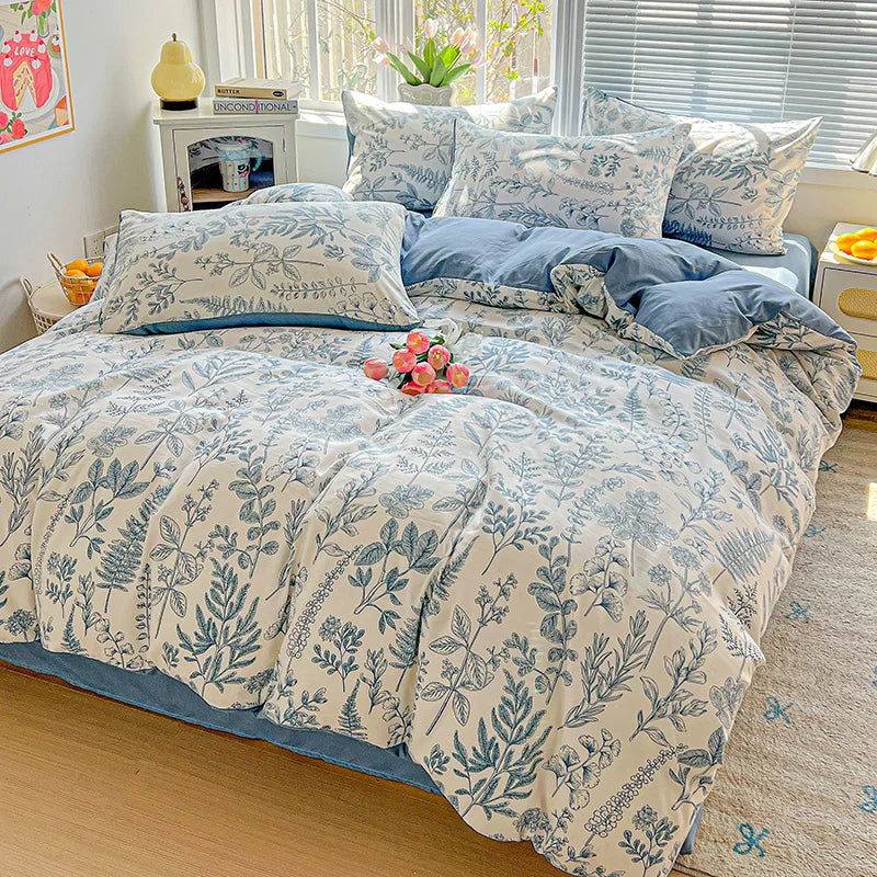 A floral duvet cover set featuring blue and white botanical patterns on a bed with natural light.