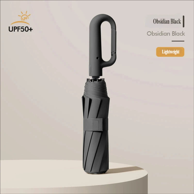 A black automatic folding umbrella with a sturdy handle is shown against a light background.