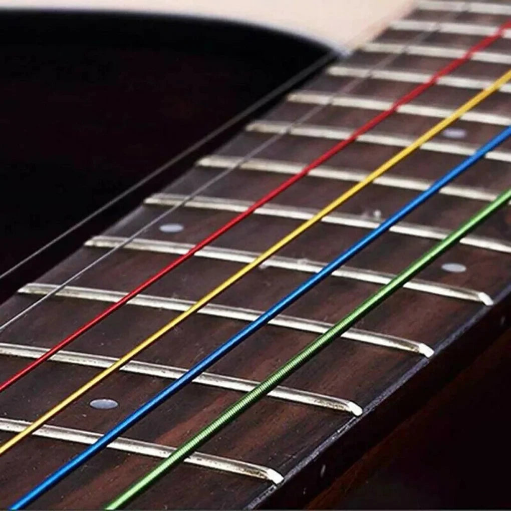Close-up view of six color-coded acoustic guitar strings laid out on the fretboard.