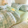A light green duvet cover featuring a white and pale blue rabbit fleece design on a bed.