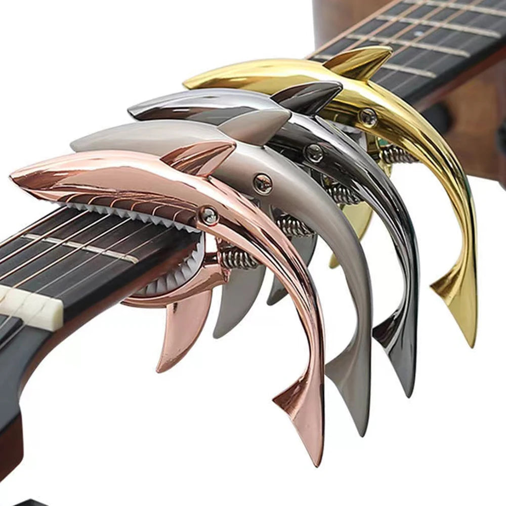 A close-up view of a pro-grade zinc alloy guitar capo with multiple colored metal shapes.