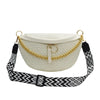 A cream woven pattern waist bag with a gold chain strap and black patterned fabric.