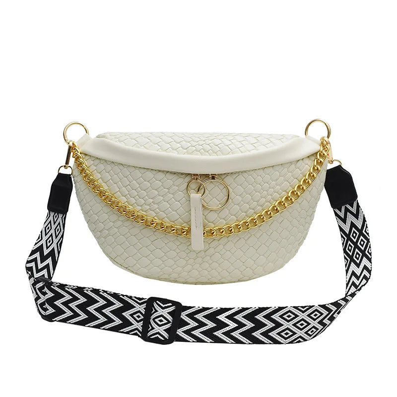 A cream woven pattern waist bag with a gold chain strap and black patterned fabric.