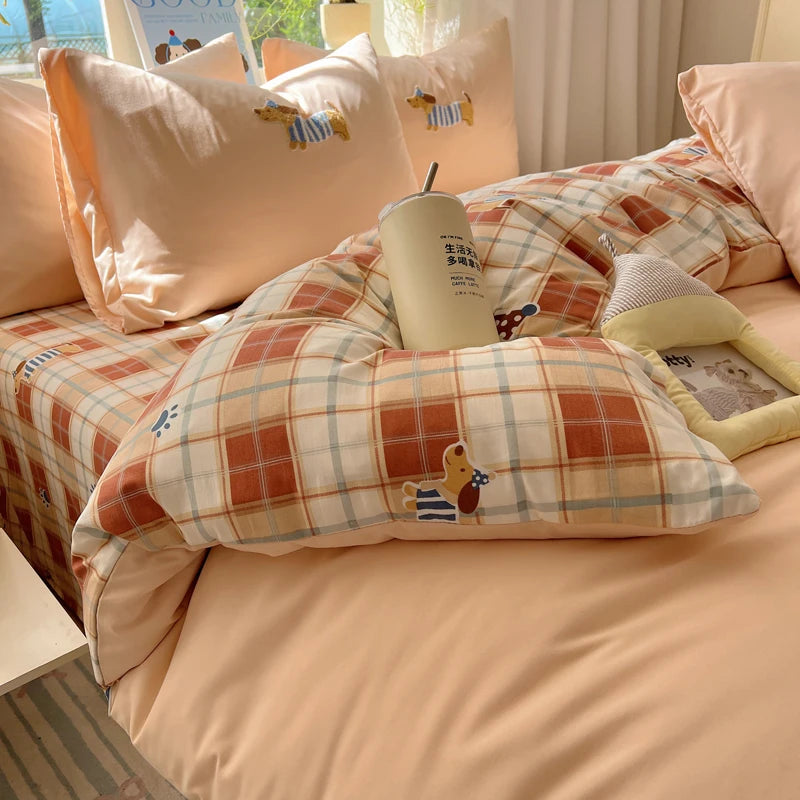 A beige cartoon embroidered duvet cover set featuring plaid patterns and a yellow cup.