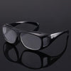 Black ergonomic reading magnifying glasses with wide lenses shown against a dark background.