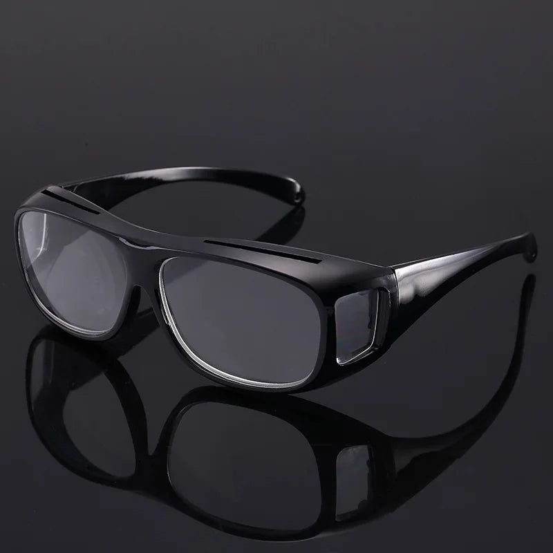 Black ergonomic reading magnifying glasses with wide lenses shown against a dark background.