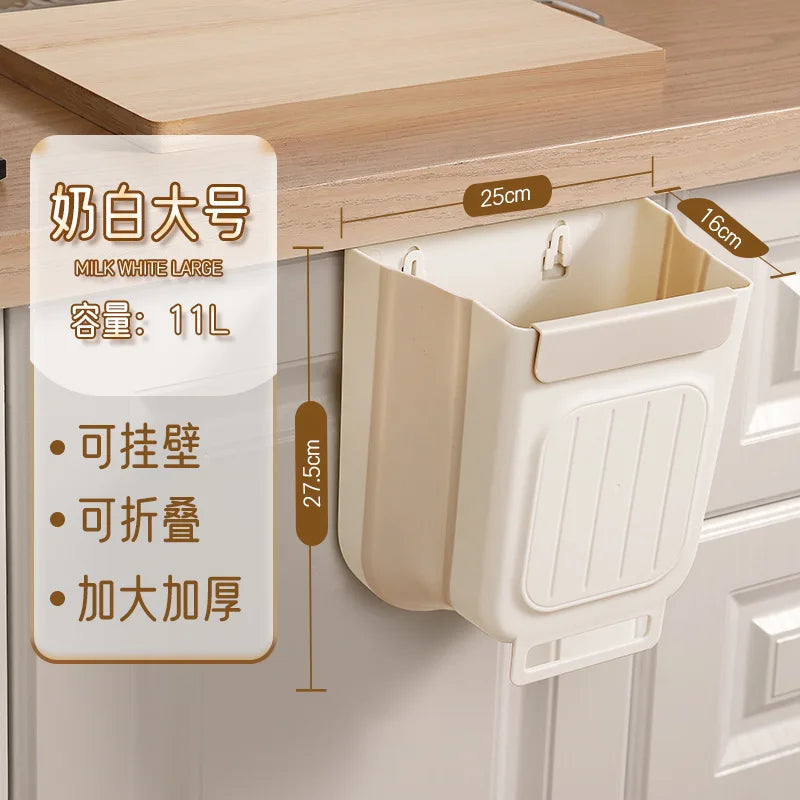 A beige foldable hanging trash bin with a lid is shown on a wooden countertop.