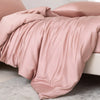 Luxuriöses rosa Bambus-Duvetcover-Set über einem Bett, mit weichen Falten und glatteren Stoff