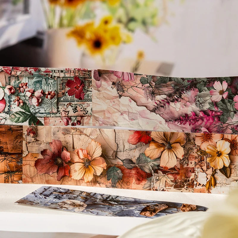 A close-up of vintage botanical washi tape featuring floral and foliage patterns for scrapbooking.