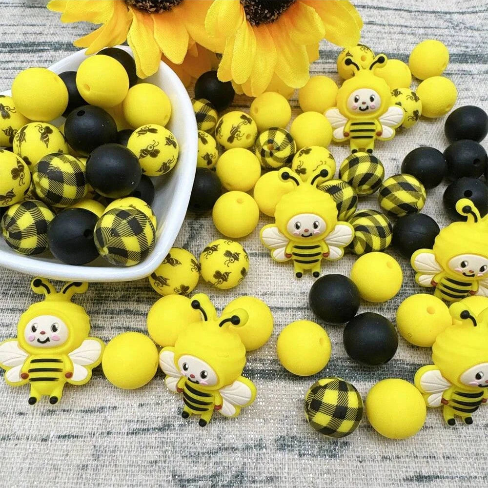 A collection of yellow and black silicone bee-shaped beads for jewelry making and DIY crafts.