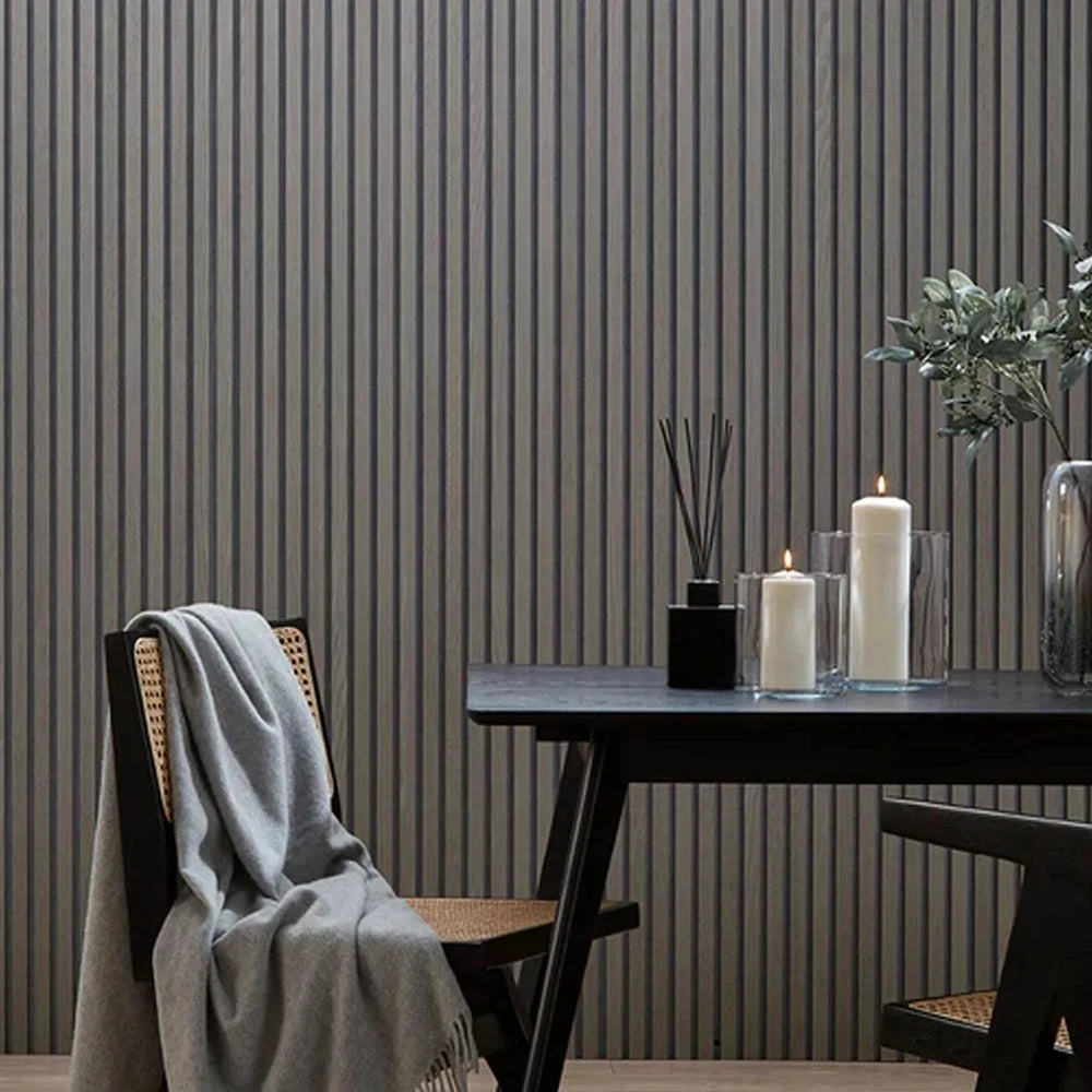 A dark wood table set against a gray vertical slat wall with candles and a draped cloth.