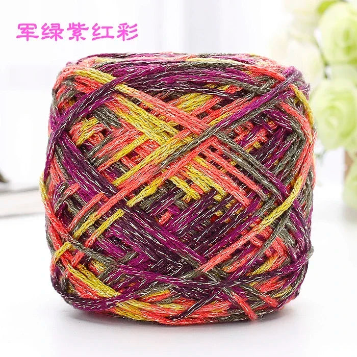 A ball of metallic silk crochet yarn with vibrant pink, yellow, and purple threads.