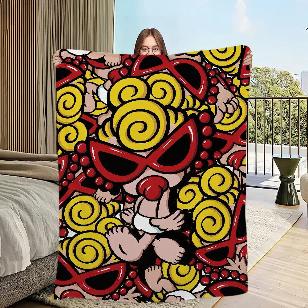 Une personne tient une couverture colorée avec un motif de formes jaunes et rouges tourbillonnantes.