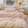 A pink floral printed duvet cover set with matching pillowcases displayed on a bed.