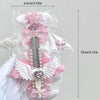 A pink and white decorative utility cutter shaped like a cat's paw with a ribbon bow and heart embellishments.