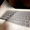 A close-up view of an ultra-thin TPU keyboard cover for a MacBook, showing the keys and palm rest design.