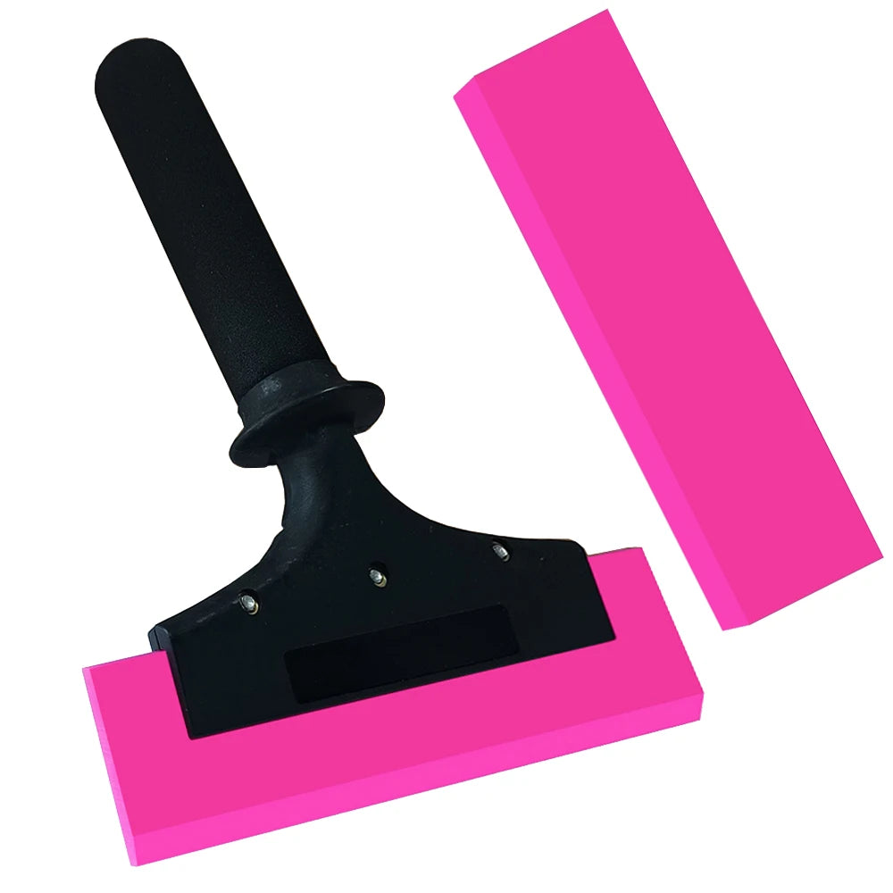 A black rubber squeegee with an anti-slip nylon handle resting on a pink surface.