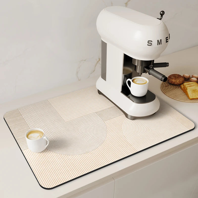 A white espresso machine is placed on a beige counter mat with concentric circles and vertical stripes.
