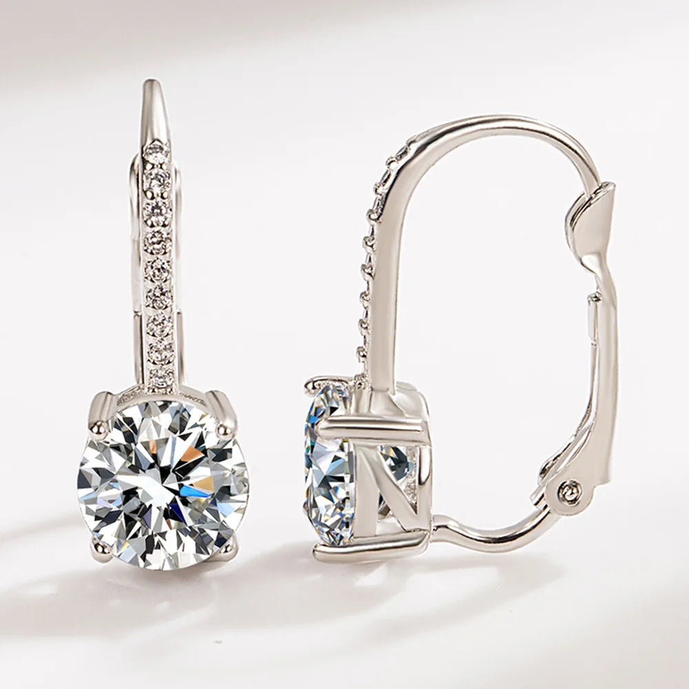 A pair of 925 sterling silver turquoise hoop earrings featuring a sparkling stone and detailed metalwork.