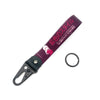 A dark purple keychain featuring an anime girl design attached to a steel clip.