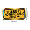 An embroidered patch with the text There is nothing basic about me on a yellow background.