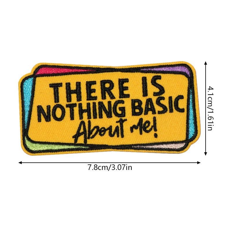 An embroidered patch with the text There is nothing basic about me on a yellow background.