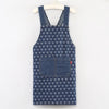 A dark blue denim cross-back apron with a repeating pattern of small white hearts and a chest pocket.