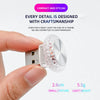 A hand holds a small, clear, ornate LED light fixture designed for car or PC interior use.