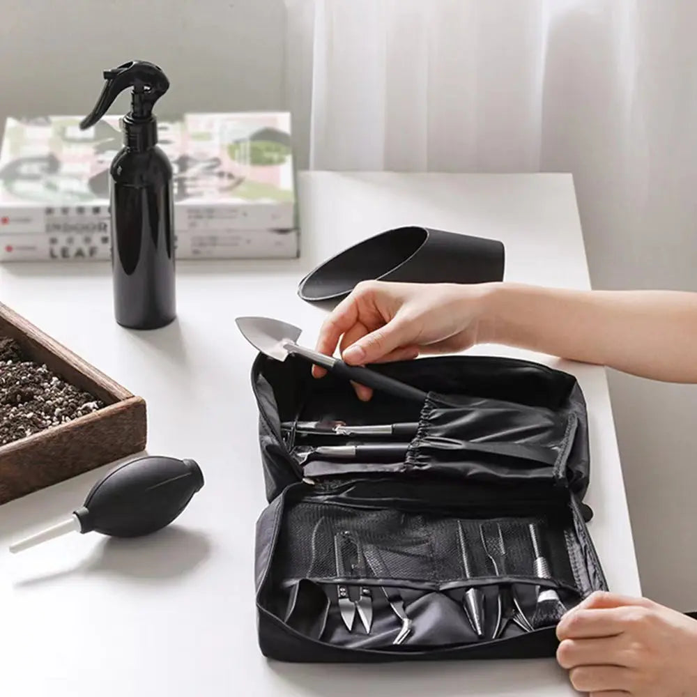 A black leather tool kit for succulent and bonsai gardening, shown open on a white table.