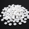 A pile of 100 white acrylic pearl spacer beads for jewelry making.