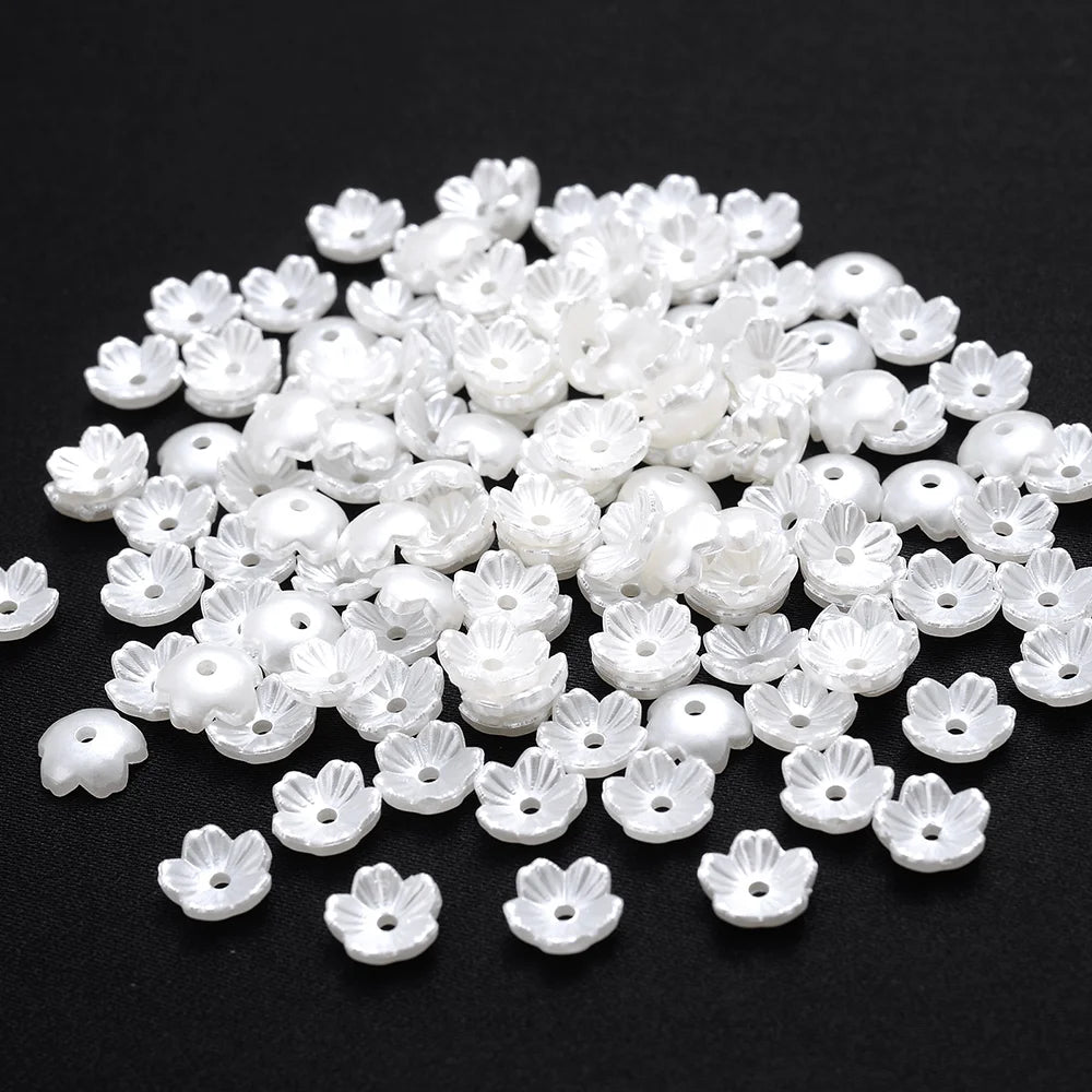 A pile of 100 white acrylic pearl spacer beads for jewelry making.