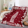 A deep red tapestry featuring white floral and star patterns, used as a bedding or sofa throw.
