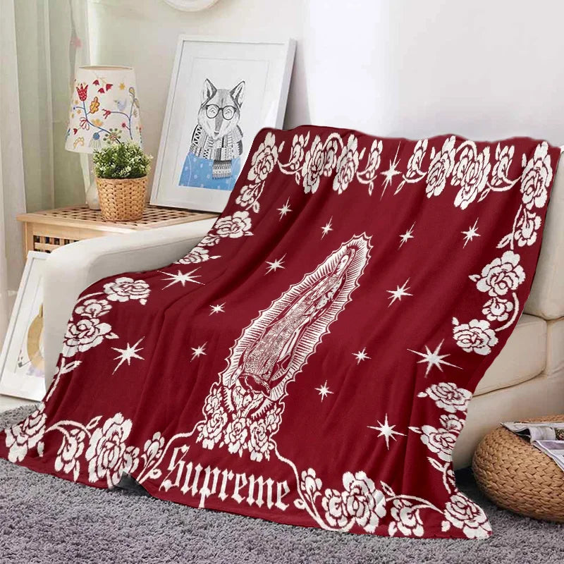 A deep red tapestry featuring white floral and star patterns, used as a bedding or sofa throw.