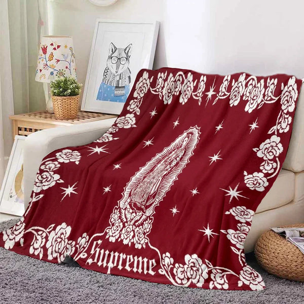A deep red tapestry featuring white floral and star patterns, used as a bedding or sofa throw.
