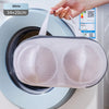 A white mesh laundry bag is shown inside a washing machine drum.