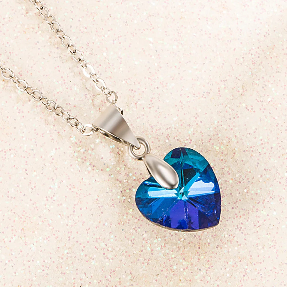 A 925 sterling silver heart zircon pendant necklace with a blue gemstone charm on a silver chain.