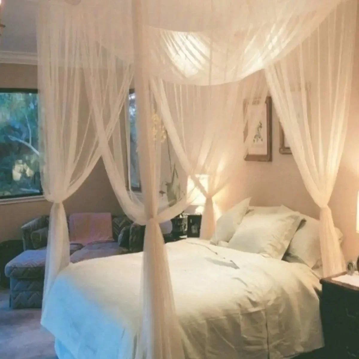 Elegant white lace canopy mosquito net draped over a bed in a bedroom setting.