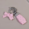 Pink PU leather bow keychain with an O-shaped silver buckle and rhinestone accents