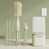 A set of silicone baby bottle brushes, including a main brush and two smaller brushes, displayed against a light green backgr
