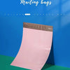 A pink thickened express mailing bag is displayed against a blue background.
