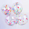 A cluster of clear balloons filled with colorful confetti paper shreds for parties and celebrations