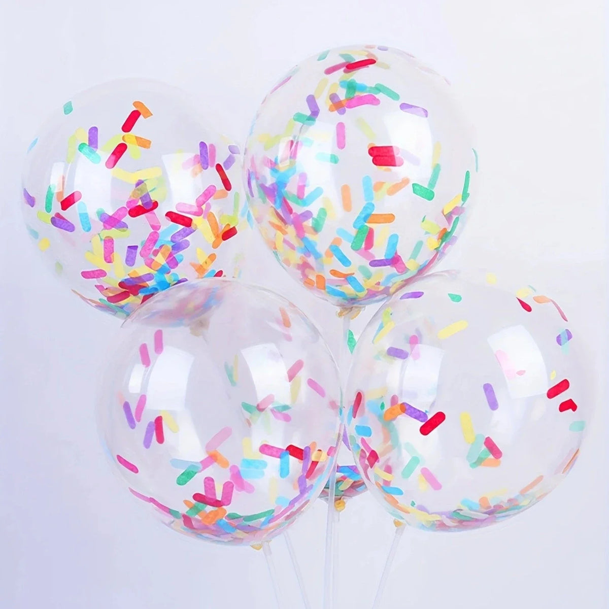 A cluster of clear balloons filled with colorful confetti paper shreds for parties and celebrations