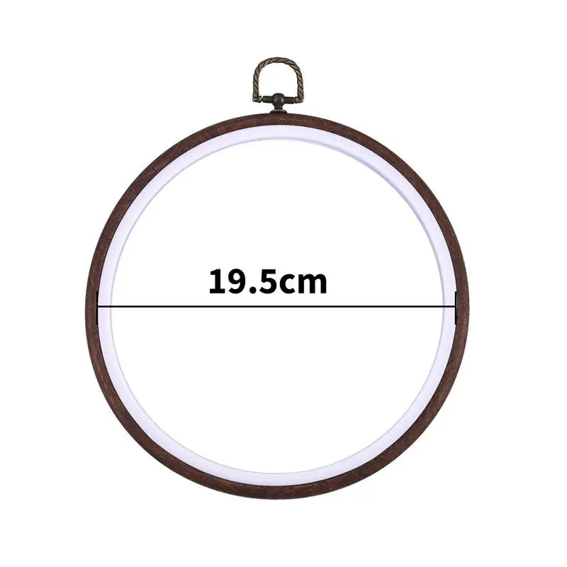 A circular wooden embroidery hoop with a metal hook for cross-stitch and needlework.
