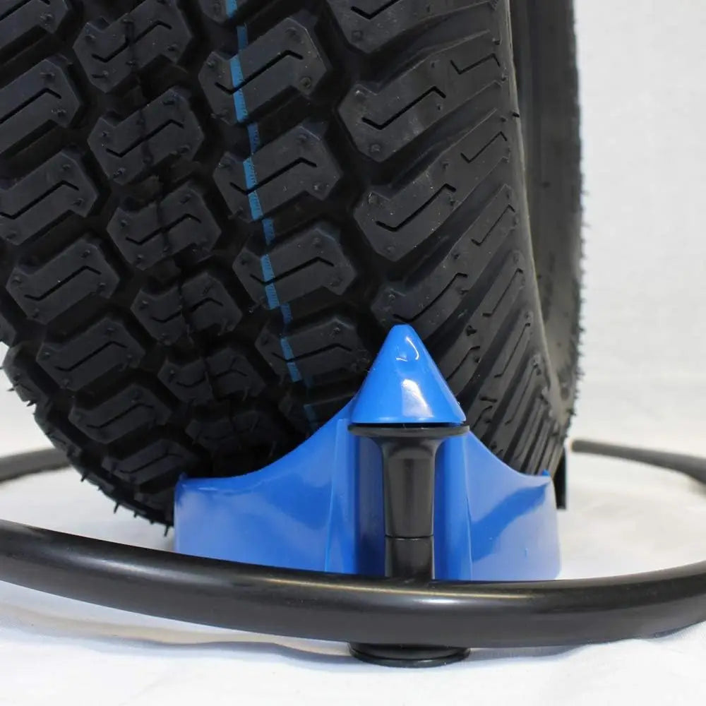 A close-up view of a black tire with tread and a blue plastic car hose guide roller wedge attached.