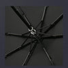 A black folding parasol or umbrella with a silver decorative element, shown from above.