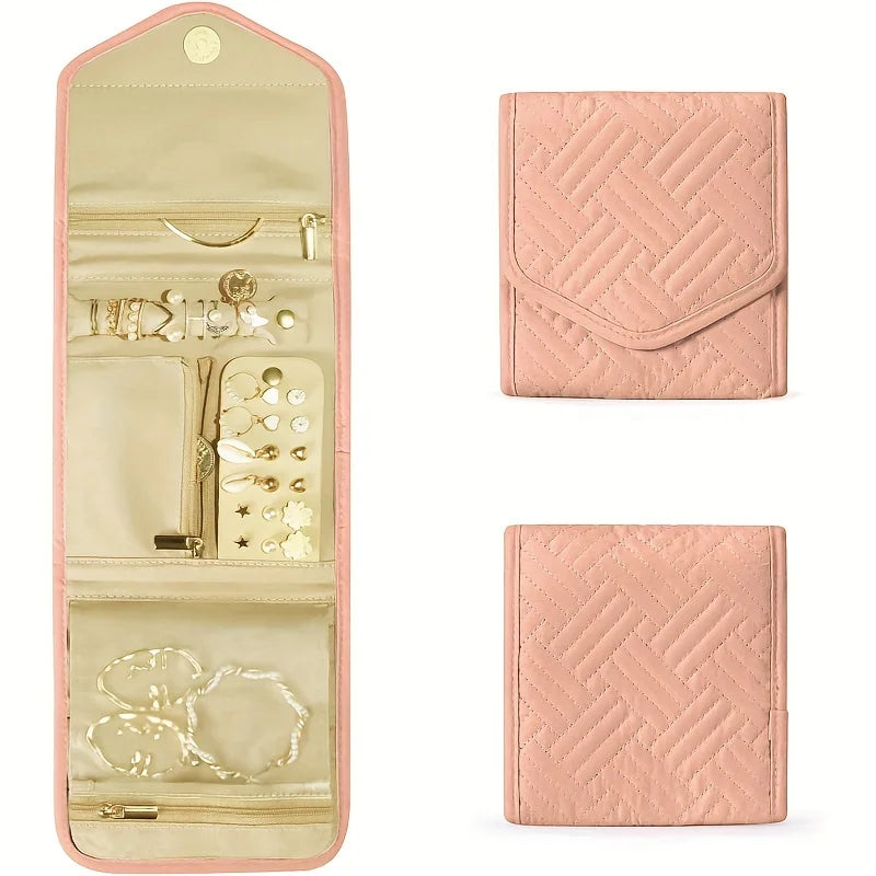 A pink foldable waterproof jewelry roll with compartments for storing and traveling with accessories.